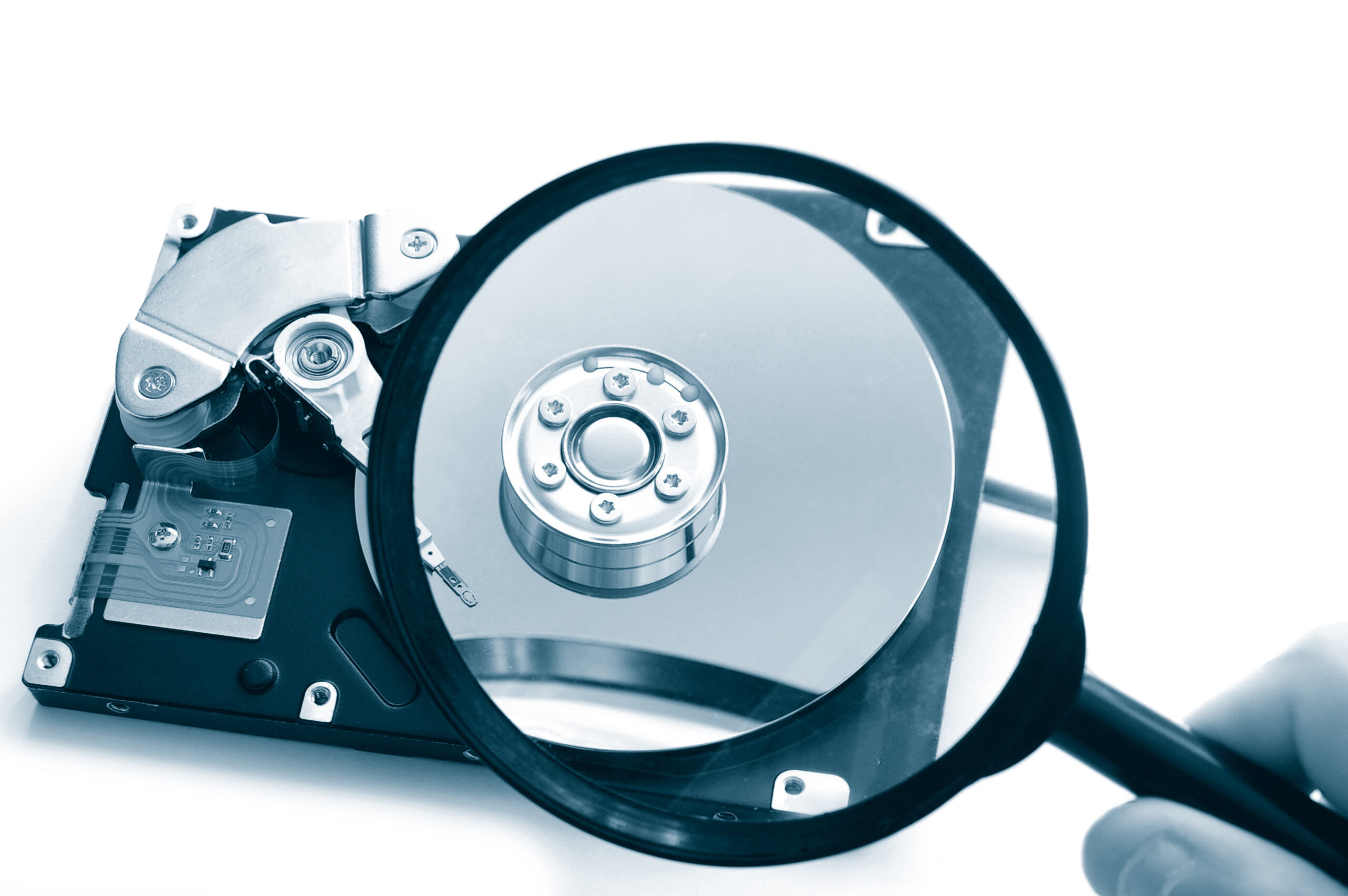 A hard drive with an investigator's spyglass in front of it.